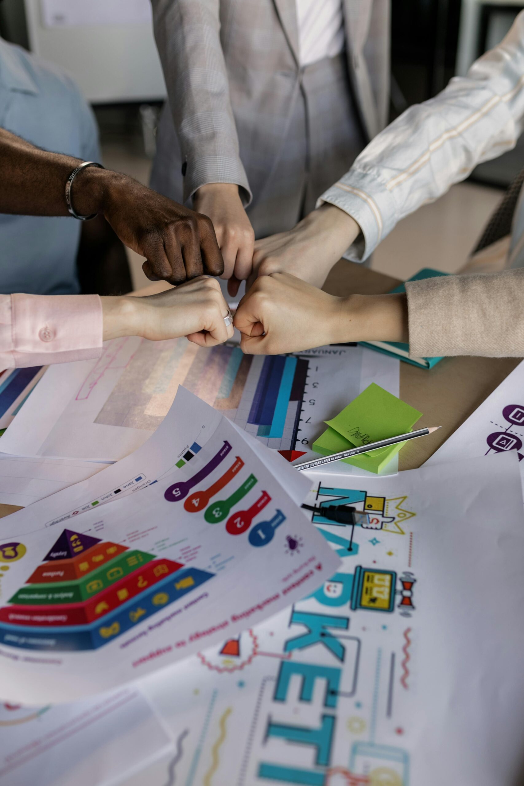 A diverse team joining hands to symbolize teamwork, trust, and commitment.